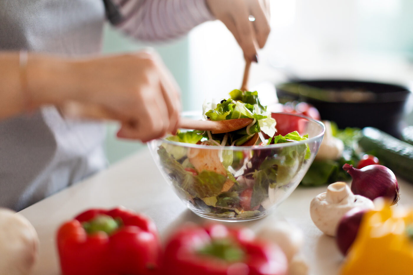 Fresh ingredients being prepared into a simple salad on a wooden surface.